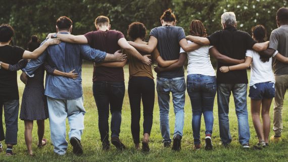 Group of friends huddle in rear view together