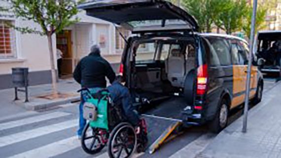 Una persona amb cadira de rodes puja a un taxi