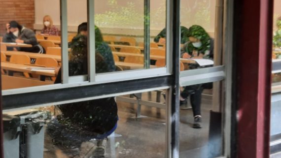 Persones fent la prova escrita en una aula.