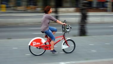 Fotografia d&#039;una noia fent servir la bicicleta pel carril bici.