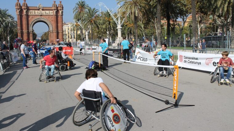Vista del passeig Lluís Companys, amb l'Arc de Triomf al fons, amb persones jugant al tennis amb cadira de rodes