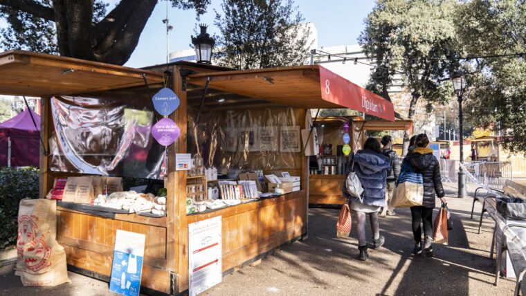 Persones passejant i comprant a les parades de la fira de consum responsable i de l'economia social i solidària