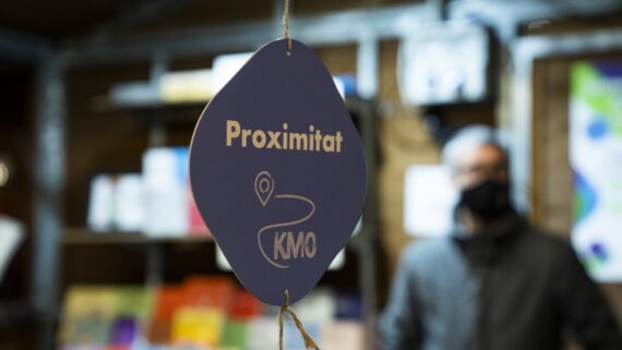 Garlanda penjada d'una parada de la Fira de Consum Responsable i d’Economia Social i Solidària amb un cartell que indica que són productes de proximitat Km0