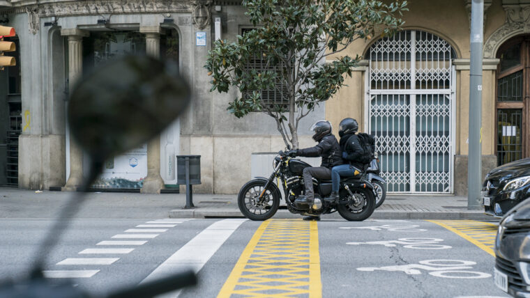 Motocicleta aturada a un semàfor amb dues persones