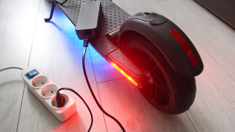 patinet elèctric endollat per carregar la bateria