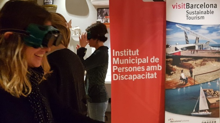 Una dona amb unes ulleres de realitat virtual participant en la jornada en una sala amb un roll up vermell al fons on posa: Institut Municipal de Persones amb Discapacitat.