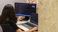 Una dona davant de les pantalles d'ordinador programant. Autora: Paula Jaume