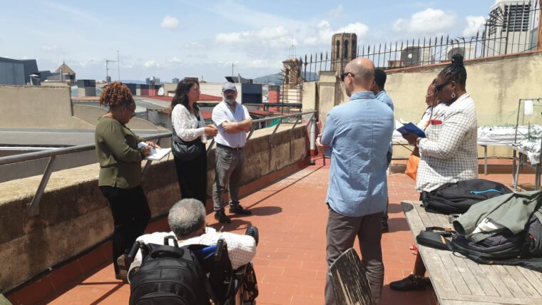 Les persones de la delegació, una d'elles amb cadira de rodes i l'equip de l'IMPD en una visita a l'Hort al Terrat del Carrer Avinyó, accessible i de la Gerència de recursos.