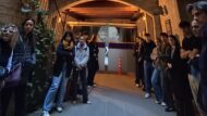 Alumnes i professors d'arquitectura estan al pati principal de la Residència Vigatans, escoltant l'explicació de la directora del centre.