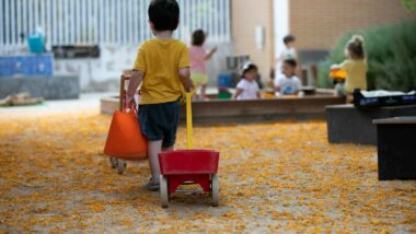 Un infant juga amb un carretó en una escola bressol municipal