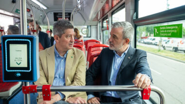 L'alcalde de Barcelona, Jaume Collboni, i l'alcalde de l'Hospitalet de Llobregat, David Quirós, conversen asseguts a l'interior d'un autobús