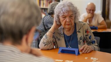 Una senyora jugant al Rummikub dins un refugi climàtic