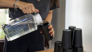 Una dona servint-se aigual en un refugi climàtic