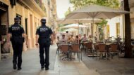 Agents de la Guàrdia Urbana passejant al costat de terrasses