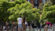Dues persones passegen per la plaça de la Universitat