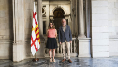Fotografia de Marta Salicrú i Jaume Collboni al costat de la bandera de Barcelona.