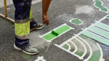Un treballador pinta el terra d&#039;una escola