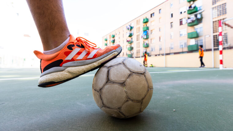 Pilota de futbol aturada amb el peu, en el Complex Esportiu Francesc Abad, al barri del Besòs i el Maresme