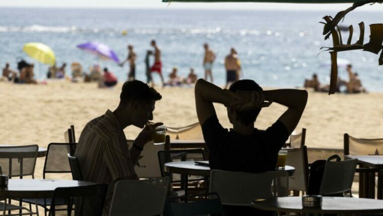 Imatge de dos nois a una guingueta de la platja
