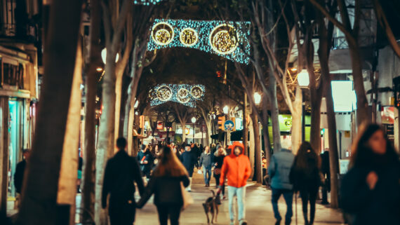 Persones passejant pel carrer de Rogent, amb les llums de Nadal enceses