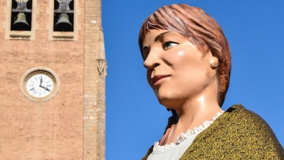 Una gigante, en el fondo, un cielo azul.