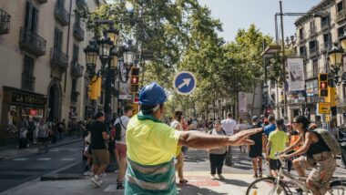 Treballador amb una indicació que dirigeix el trànsit de ciclistes i vianants a la Rambla