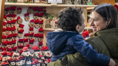 Mare i fill davant d'una botiga de tions de la Fira de Santa Llúcia.
