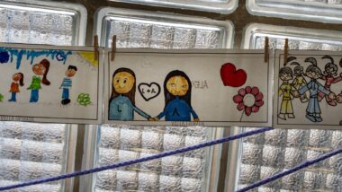 Dibuixos infantils penjats a la finestra d'una escola.
