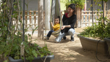 Infant jugant al pati d'una escola amb la seva mare, en el marc de la iniciativa "Patis oberts"