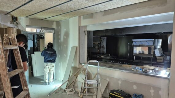 Uns treballadors fan obres de millora a la cuina de l'Escola Aldana a l'Eixample.